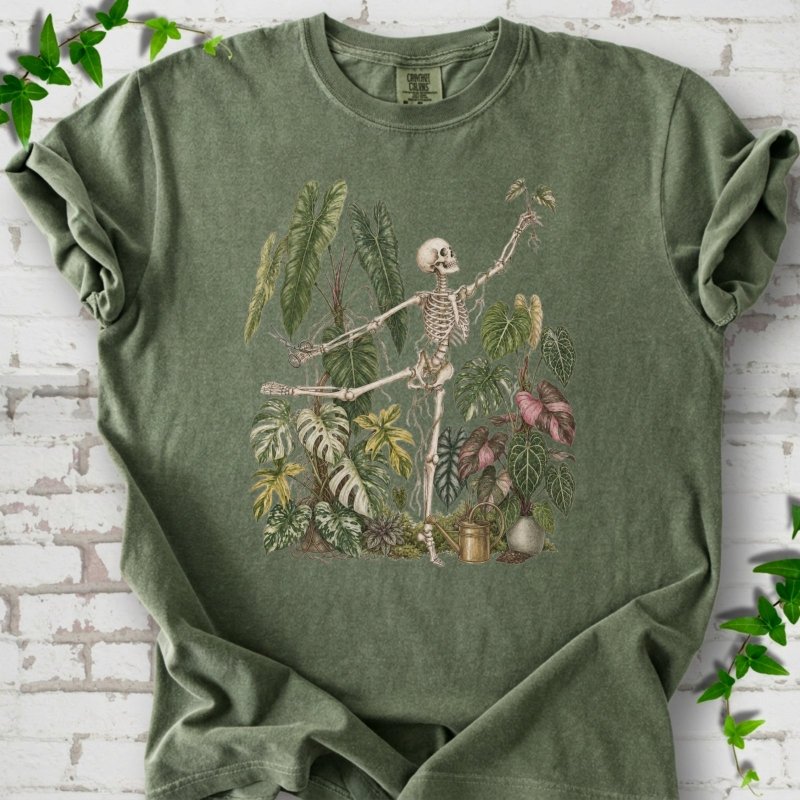 Moss Comfort Colors® T-shirt front mockup featuring a skeleton tending a collection of leafy houseplants.