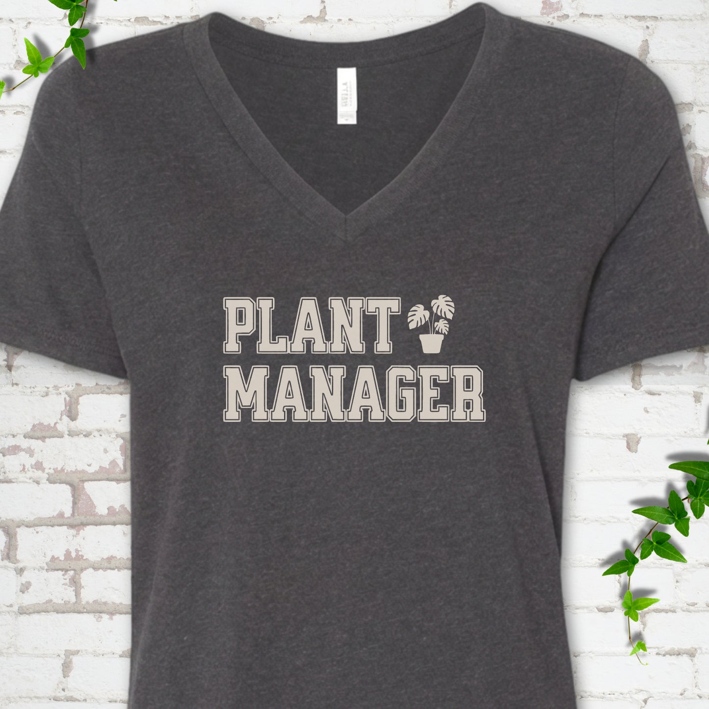 Dark Grey Heather Bella Canvas® V-neck T-shirt front mockup featuring the collegiate Plant Manager design with a potted monstera.