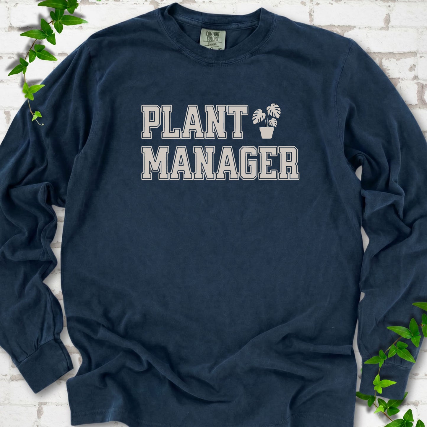 Midnight Comfort Colors® long sleeve T-shirt front mockup featuring the collegiate Plant Manager design with a potted monstera.