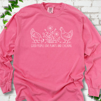 Crunchberry long-sleeve T-shirt flat lay with white line-art hens and flowers above the words "Good People Love Plants and Chickens."