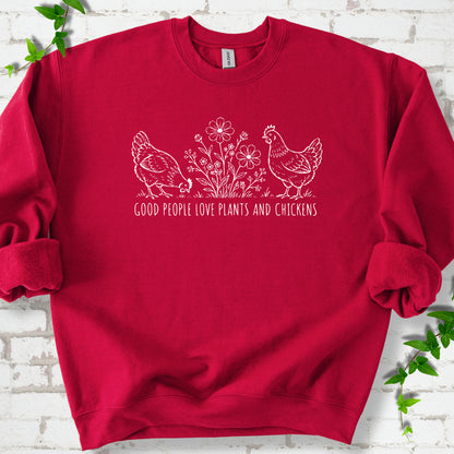 Cardinal Red crewneck sweatshirt flat lay with white line-art hens and flowers above the words "Good People Love Plants and Chickens."