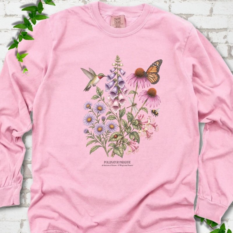 Blossom Comfort Colors® long sleeve T-shirt flat lay featuring a hummingbird, monarch butterfly and bee among foxglove, coneflowers and asters with Pollinator Paradise text.