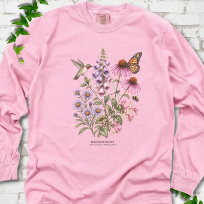 Blossom Comfort Colors® long sleeve T-shirt flat lay featuring a hummingbird, monarch butterfly and bee among foxglove, coneflowers and asters with Pollinator Paradise text.