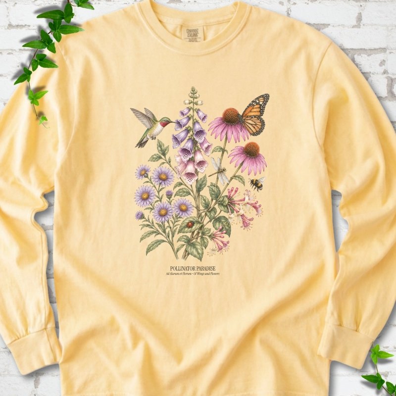 Butter Comfort Colors® long sleeve T-shirt flat lay featuring a hummingbird, monarch butterfly and bee among foxglove, coneflowers and asters with Pollinator Paradise text.