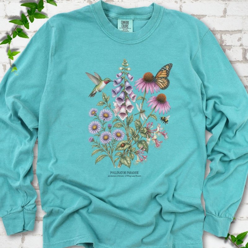 Seafoam Comfort Colors® long sleeve T-shirt flat lay featuring a hummingbird, monarch butterfly and bee among foxglove, coneflowers and asters with Pollinator Paradise text.