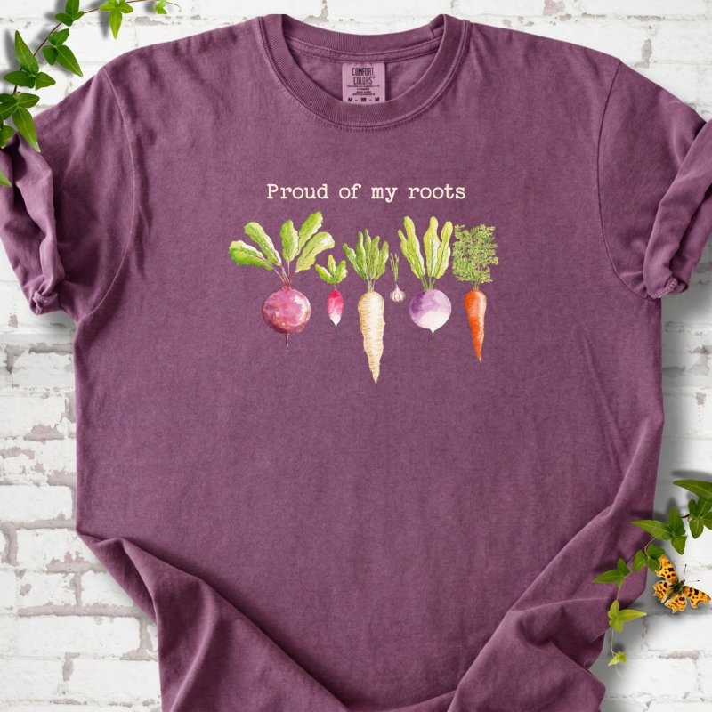 Berry Comfort Colors® T-shirt shown flat with "Proud of My Roots" text above watercolor-style root vegetables