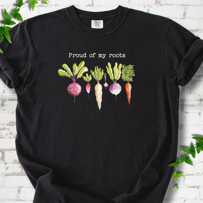 Black Comfort Colors® T-shirt shown flat with "Proud of My Roots" text above watercolor-style root vegetables