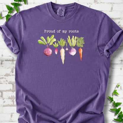 Grape Comfort Colors® T-shirt shown flat with "Proud of My Roots" text above watercolor-style root vegetables