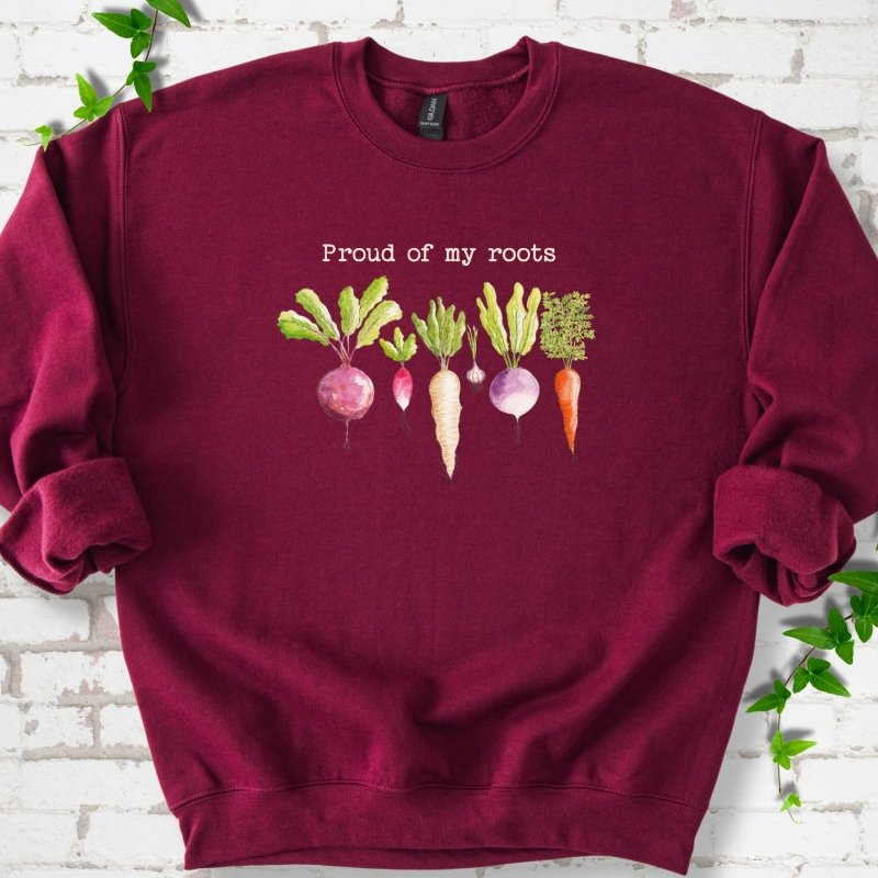 Maroon classic sweatshirt shown flat with "Proud of My Roots" text above watercolor-style root vegetables