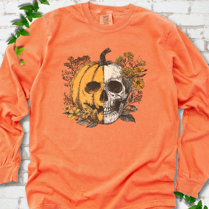 Melon Comfort Colors® long sleeve T-shirt flat lay featuring a half-pumpkin, half-skull botanical Halloween graphic.