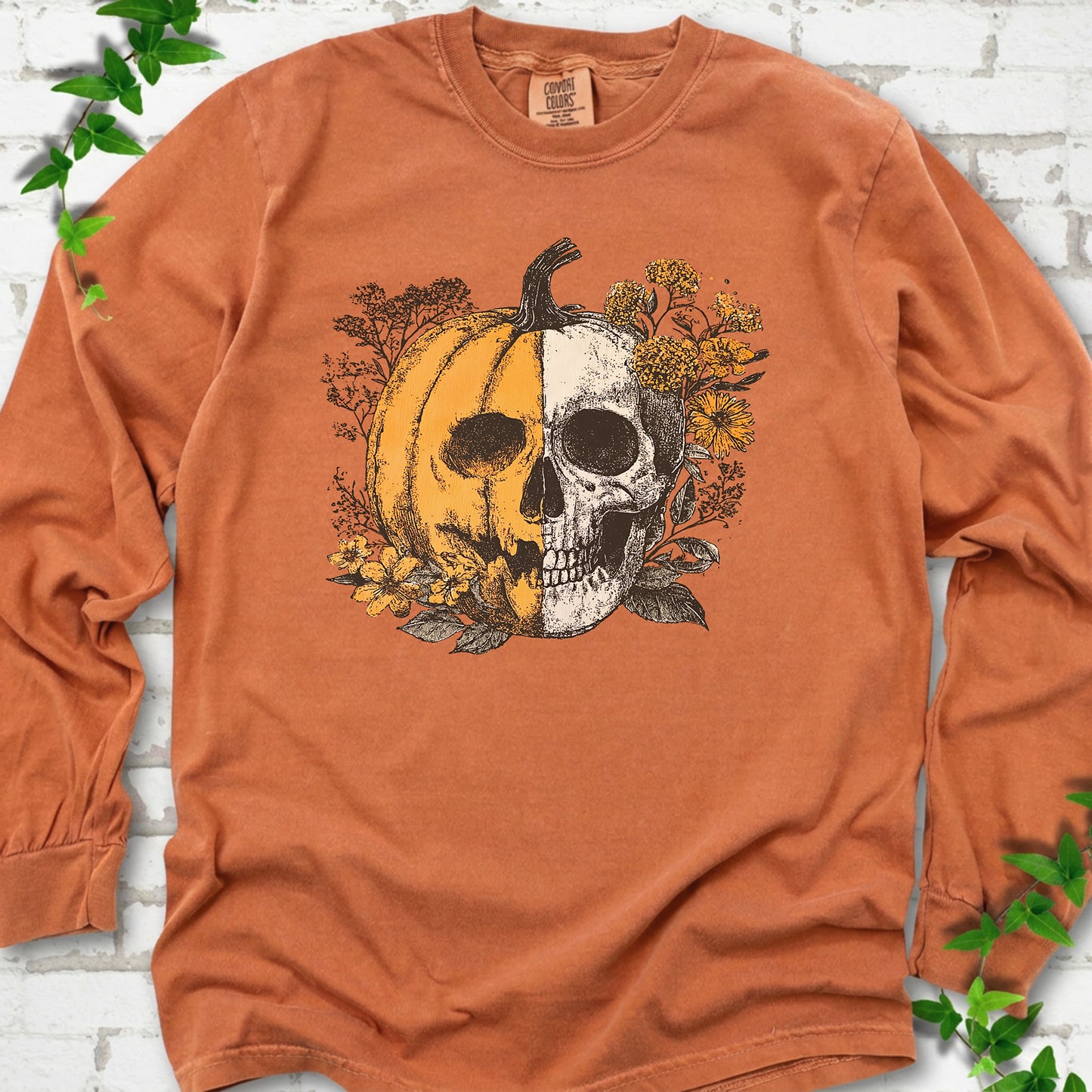 Yam Comfort Colors® long sleeve T-shirt flat lay featuring a half-pumpkin, half-skull botanical Halloween graphic.