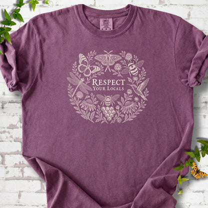 Berry Comfort Colors® T-shirt flat lay featuring the words “Respect Your Locals” surrounded by pollinating insects, a hummingbird and flowers.