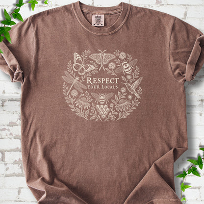 Espresso Comfort Colors® T-shirt flat lay featuring the words “Respect Your Locals” surrounded by pollinating insects, a hummingbird and flowers.