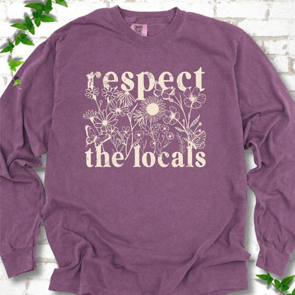 Berry Comfort Colors® long sleeve T-shirt flat lay featuring the words Respect the Locals with native wildflowers and pollinators.