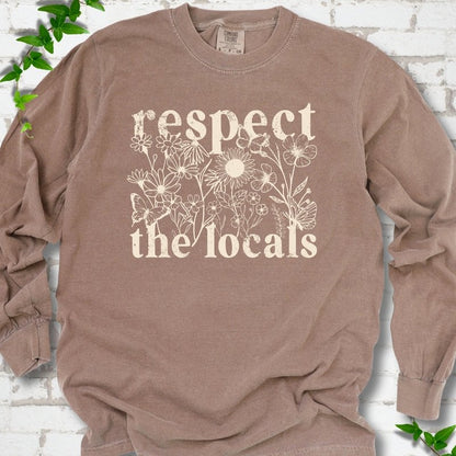 Espresso Comfort Colors® long sleeve T-shirt flat lay featuring the words Respect the Locals with native wildflowers and pollinators.