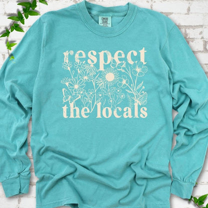Seafoam Comfort Colors® long sleeve T-shirt flat lay featuring the words Respect the Locals with native wildflowers and pollinators.