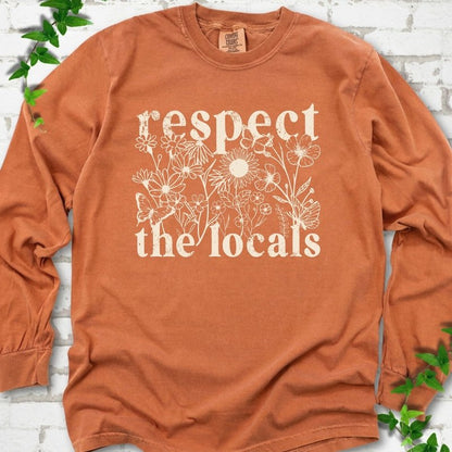 Yam Comfort Colors® long sleeve T-shirt flat lay featuring the words Respect the Locals with native wildflowers and pollinators.