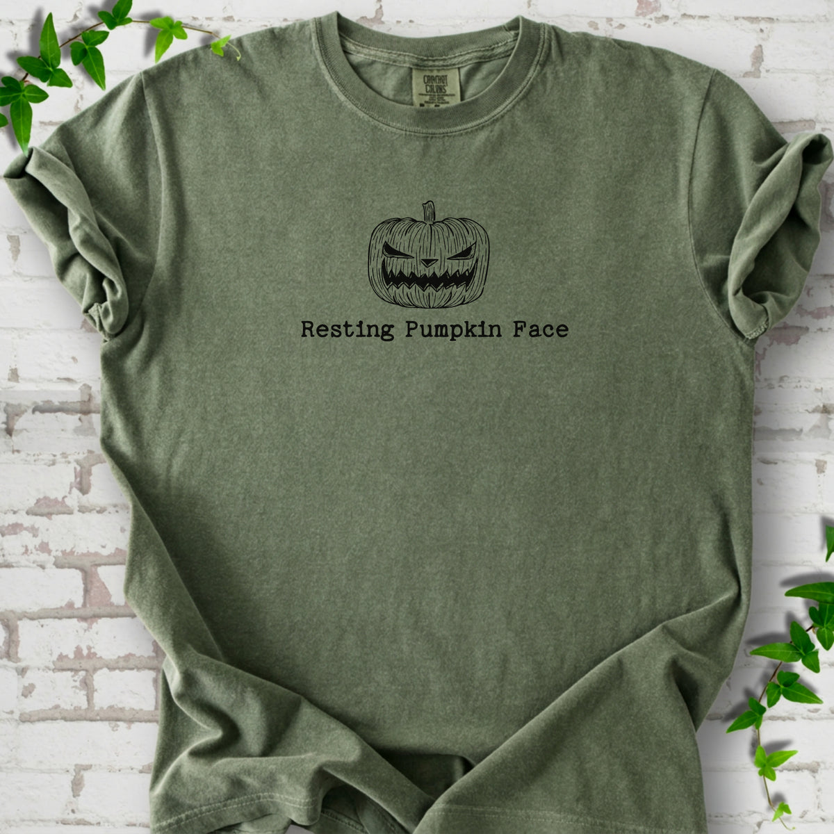 Resting Pumpkin Face funny Halloween T-shirt in Moss with jack-o'-lantern face graphic