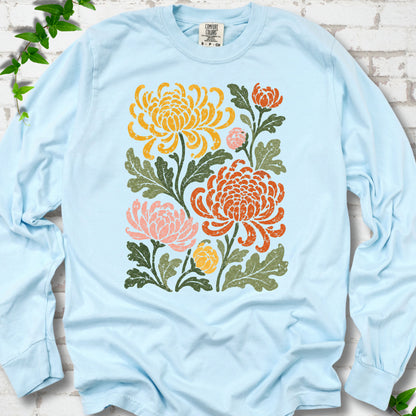 Chambray Comfort Colors® long sleeve T-shirt flat lay with a distressed multicolor chrysanthemum garden graphic on a white brick background with ivy accents