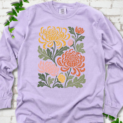 Orchid Comfort Colors® long sleeve T-shirt flat lay with a distressed multicolor chrysanthemum garden graphic on a white brick background with ivy accents