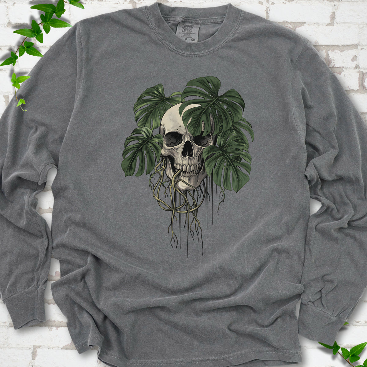 Pepper Comfort Colors T-shirt shown flat with the Root Bound Monstera skull and trailing roots graphic