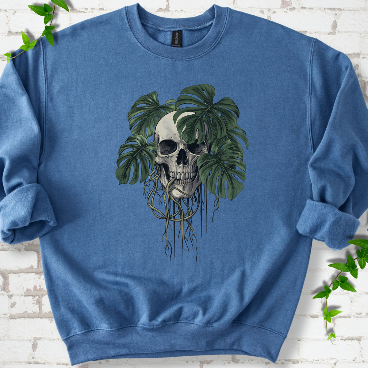 Indigo Blue classic sweatshirt shown flat with the Root Bound Monstera skull and trailing roots graphic