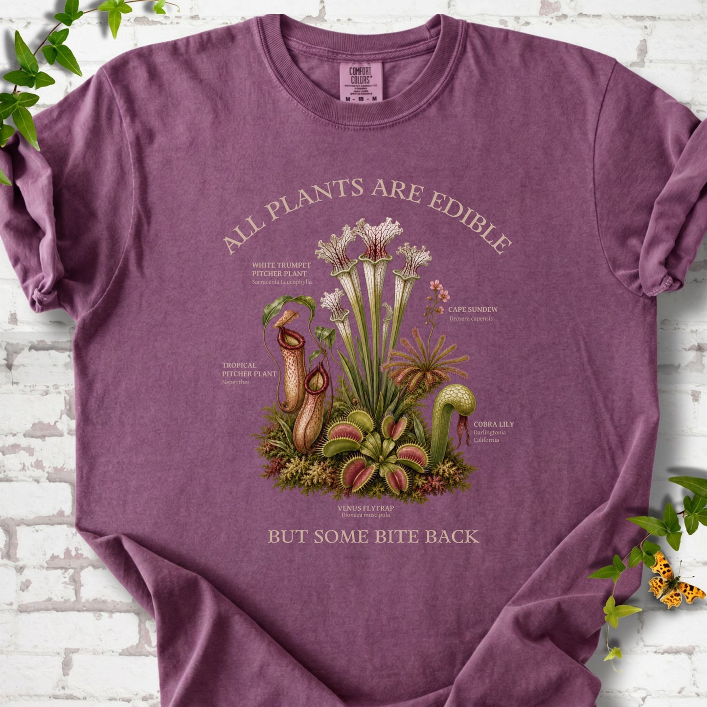 Berry Comfort Colors® T-shirt front mockup featuring a botanical illustration of various carnivorous plants including a Venus Flytrap, Pitcher Plants, Cape Sundew, and Cobra Lily.