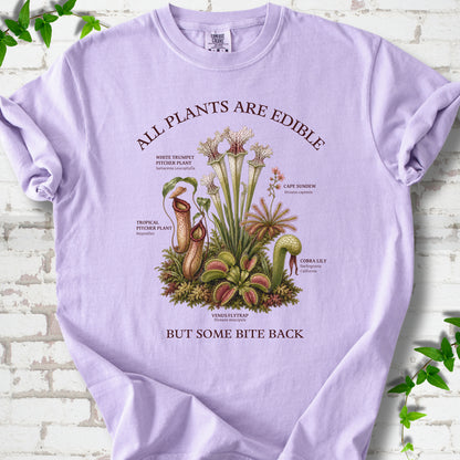 Orchid Comfort Colors® T-shirt front mockup featuring a botanical illustration of various carnivorous plants including a Venus Flytrap, Pitcher Plants, Cape Sundew, and Cobra Lily.