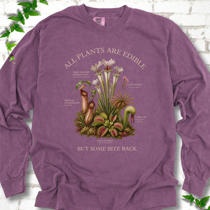 Berry Comfort Colors® long sleeve T-shirt front mockup featuring a botanical illustration of various carnivorous plants including a Venus Flytrap, Pitcher Plants, Cape Sundew, and Cobra Lily.