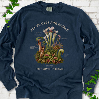 Midnight Comfort Colors® long sleeve T-shirt front mockup featuring a botanical illustration of various carnivorous plants including a Venus Flytrap, Pitcher Plants, Cape Sundew, and Cobra Lily.