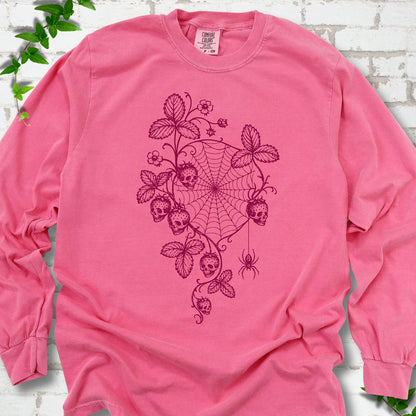 Crunchberry Comfort Colors® long sleeve T-shirt flat lay featuring skull-shaped strawberries, curling leaves, a spiderweb and a hanging spider.