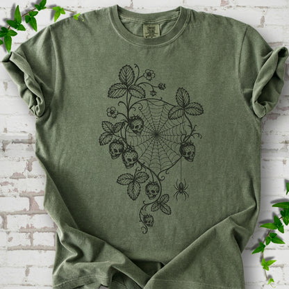Moss Comfort Colors® T-shirt flat lay featuring skull-shaped strawberries, curling leaves, a spiderweb and a hanging spider.