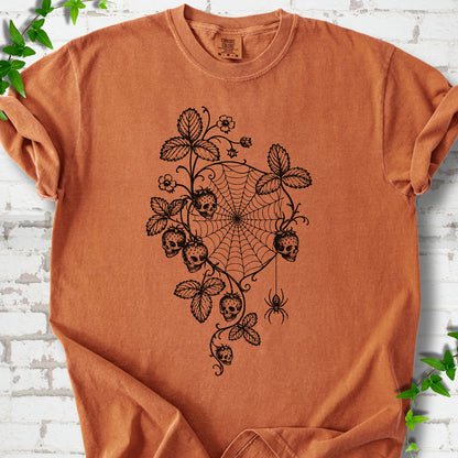 Yam Comfort Colors® T-shirt flat lay featuring skull-shaped strawberries, curling leaves, a spiderweb and a hanging spider.
