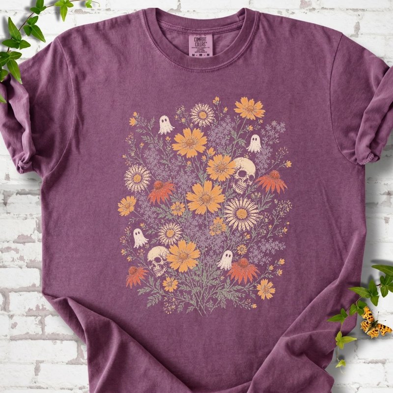 Berry Comfort Colors® T-shirt flat lay featuring a colorful wildflower bouquet with tiny ghosts and skulls.