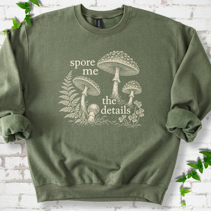 Military green crewneck sweatshirt with "spore me the details" and engraved toadstools, fern and clover in cream ink