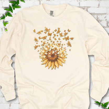 Ivory Comfort Colors® long sleeve T-shirt flat lay featuring a sunflower releasing a burst of orange butterflies.