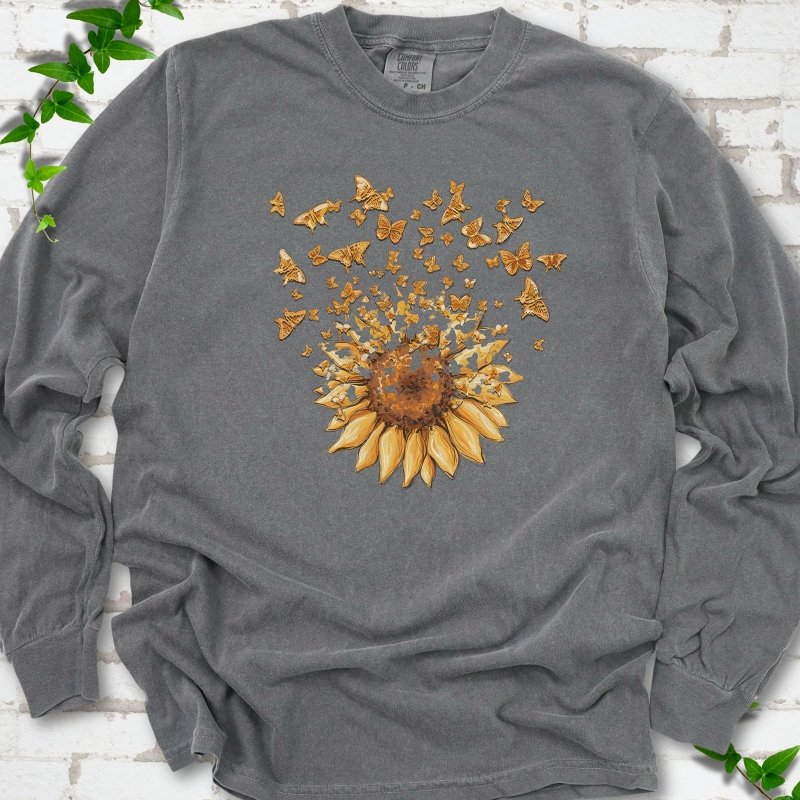 Pepper Comfort Colors® long sleeve T-shirt flat lay featuring a sunflower releasing a burst of orange butterflies.