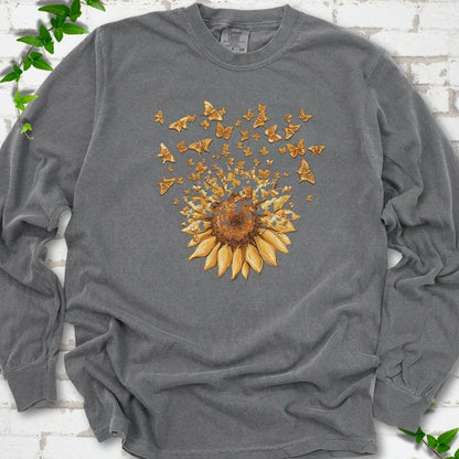 Pepper Comfort Colors® long sleeve T-shirt flat lay featuring a sunflower releasing a burst of orange butterflies.