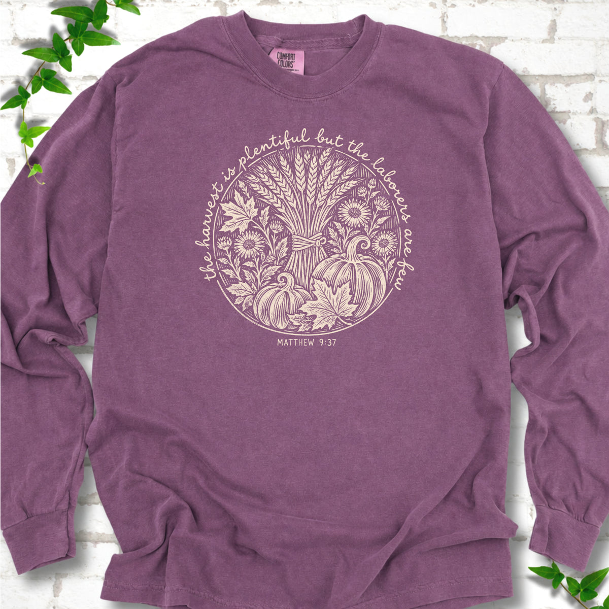 Berry long sleeve T-shirt flat lay with cream wheat, pumpkins and leaves in a harvest circle, the Matthew 9:37 verse around it and its reference below.