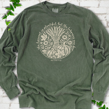 Hemp long sleeve T-shirt flat lay with cream wheat, pumpkins and leaves in a harvest circle, the Matthew 9:37 verse around it and its reference below.