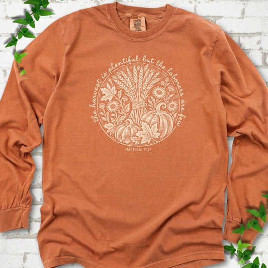 Yam long sleeve T-shirt flat lay with cream wheat, pumpkins and leaves in a harvest circle, the Matthew 9:37 verse around it and its reference below.