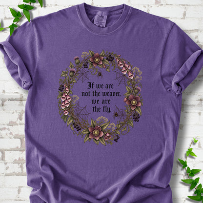 Grape T-shirt flat-lay mockup with a gothic floral wreath, spider webs and "If we are not the weaver, we are the fly" lettering.