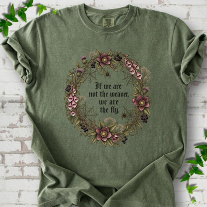 Hemp T-shirt flat-lay mockup with a gothic floral wreath, spider webs and "If we are not the weaver, we are the fly" lettering.
