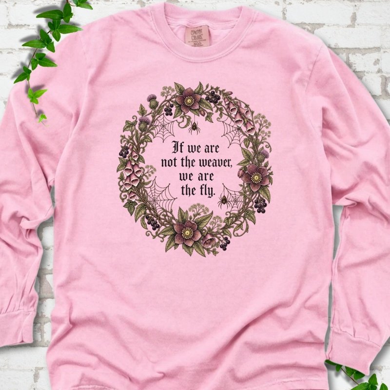 Blossom long sleeve T-shirt flat-lay mockup with a gothic floral wreath, spider webs and "If we are not the weaver, we are the fly" lettering.