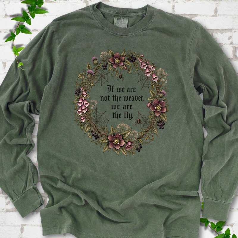 Hemp long sleeve T-shirt flat-lay mockup with a gothic floral wreath, spider webs and "If we are not the weaver, we are the fly" lettering.