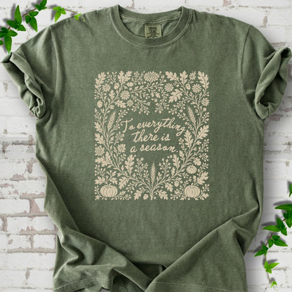 Moss Comfort Colors® T-shirt flat lay with botanical To Everything There Is a Season Bible verse artwork.
