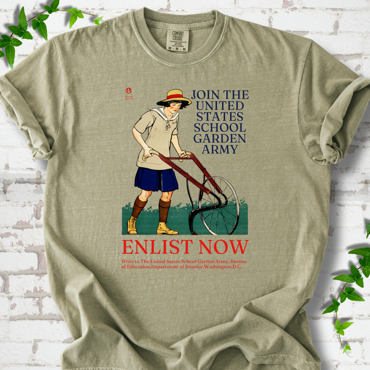 Khaki Comfort Colors® T-shirt featuring Edward Penfield’s 1918 School Garden Army poster with a young gardener, wheel hoe and “Enlist Now” text.