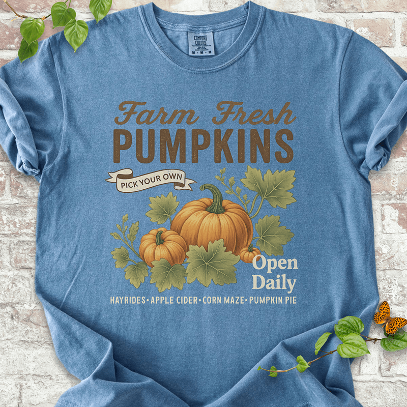 Vintage Pumpkin T-shirt on Comfort Colors™ Blue Jean – shows a nostalgic pumpkin patch design with orange pumpkins, green leaves, and rustic fall market text including "Hayrides" and "Apple Cider"