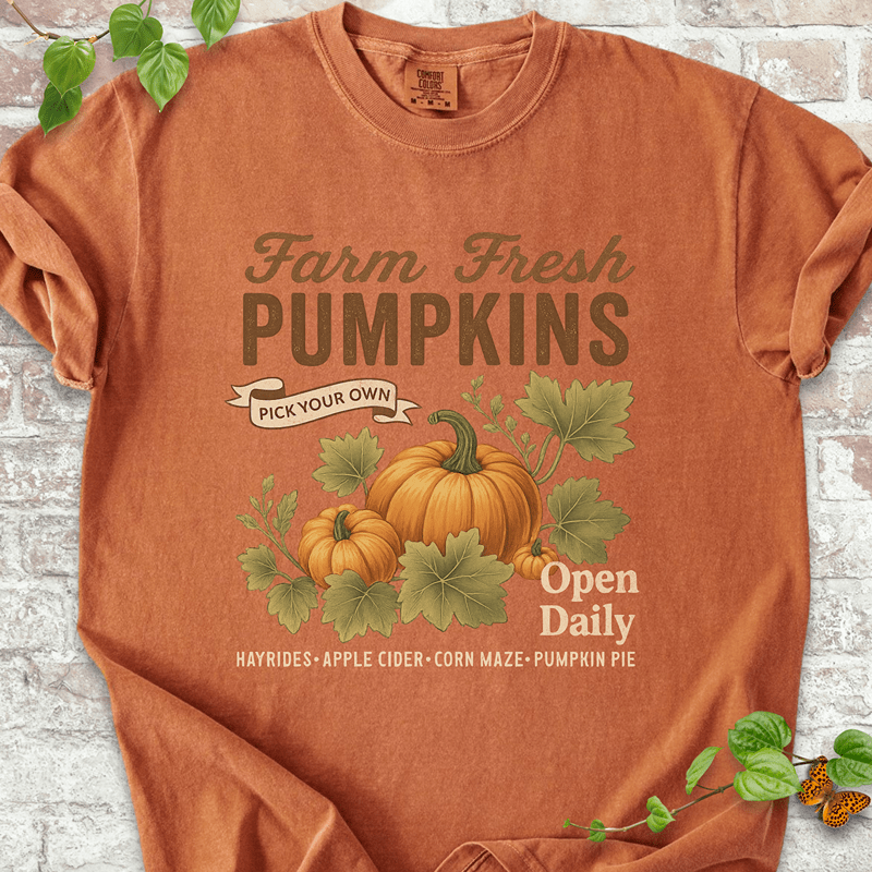 Vintage Pumpkin T-shirt on Comfort Colors™ Yam – shows warm autumn tones with vintage-style pumpkins and the phrase "Open Daily" below leafy fall-themed artwork