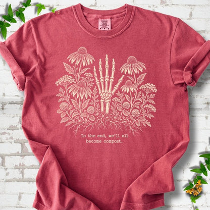Crimson Comfort Colors® T-shirt featuring a cream botanical skeleton-hand graphic reading In the end, we'll all become compost